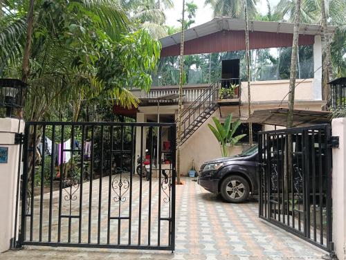 a car parked in front of a house with a gate at Dlite villa home stay in Revadanda