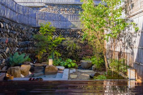 a garden with a stone wall and a wooden bench at 北京一瓢客栈 Beijing YiPiao Inn in Beijing