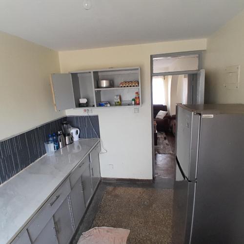 a kitchen with a stainless steel refrigerator in a room at Evin apartment in Gilgil