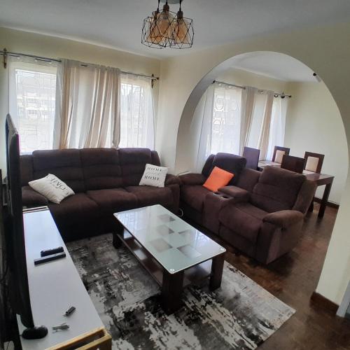 a living room with two couches and a coffee table at Evin apartment in Gilgil