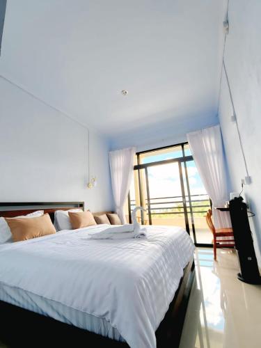 a bedroom with a large bed and a large window at Laras Homestay Munduk in Munduk