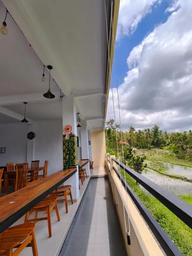 a balcony with wooden chairs and a view of the river at Laras Homestay Munduk in Munduk