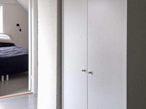 a bedroom with a white closet with a mirror at Seaside Retreat in Bandholm-By Traum in Bandholm