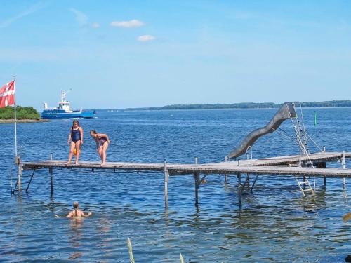three women are standing on a dock in the water at Seaside Retreat in Bandholm-By Traum in Bandholm
