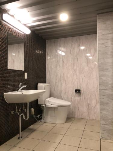 a bathroom with a sink and a toilet and a mirror at ホテルバリビーチ in Miyaki