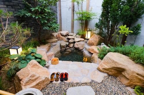 a garden with a pond with a pair of flip flops at 北京一瓢客栈 Beijing YiPiao Inn in Beijing