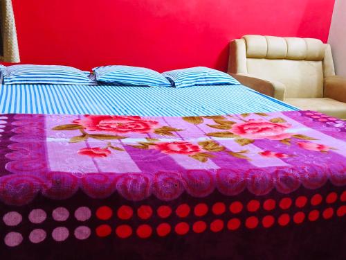a bed with a purple blanket with roses on it at Hotel Golden Touch in Digha