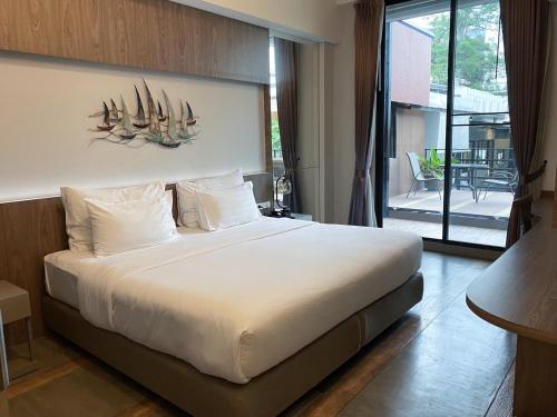 a bedroom with a large bed and a balcony at V20 Boutique Jacuzzi Hotel in Bangkok