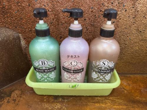 three bottles of different colored drinks in a container at Tsuyukusa in Takayama