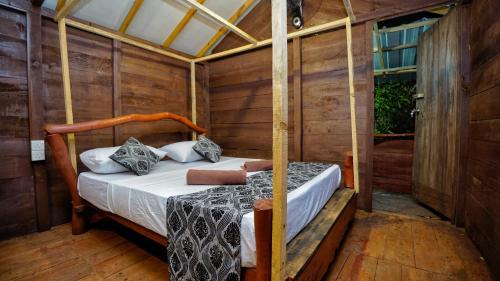 a bedroom with a bed in a wooden room at Farming Tree House in Sigiriya