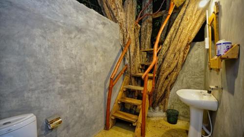 a bathroom with a staircase leading up to a tree at Farming Tree House in Sigiriya