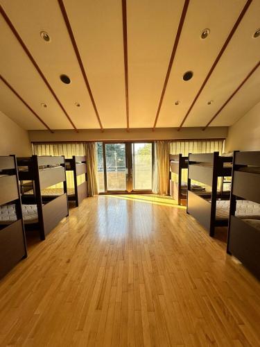 a large room with bunk beds and a wooden floor at Spacious accommodation near Narita Airport! in Yachimata