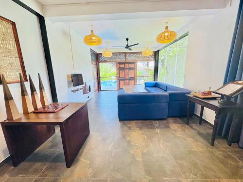 a living room with a blue couch and a table at Waterland in Negombo