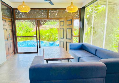 a living room with a blue couch and a table at Waterland in Negombo