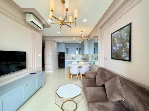 a living room with a couch and a television at The Sun Avenue Apartment Moonlight in Ho Chi Minh City