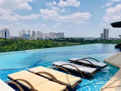 a swimming pool with chaise lounge chairs on top of a building at The Sun Avenue Apartment Moonlight in Ho Chi Minh City