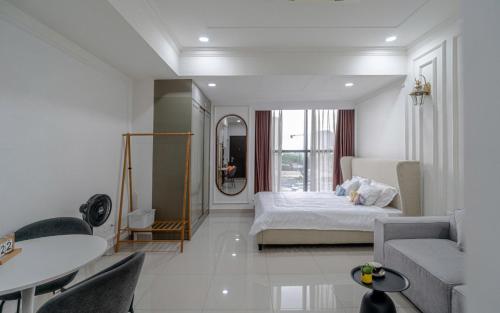 a white room with a bed and a couch at The Sun Avenue Apartment Moonlight in Ho Chi Minh City