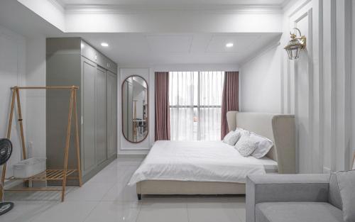 a white bedroom with a bed and a window at The Sun Avenue Apartment Moonlight in Ho Chi Minh City
