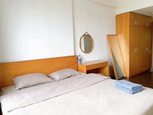 a bedroom with a large white bed with a mirror at The Sun Avenue Apartment Moonlight in Ho Chi Minh City
