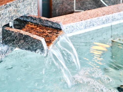 a stone water fountain with a beehive at Sun Urashima Yuki no Sato in Toba