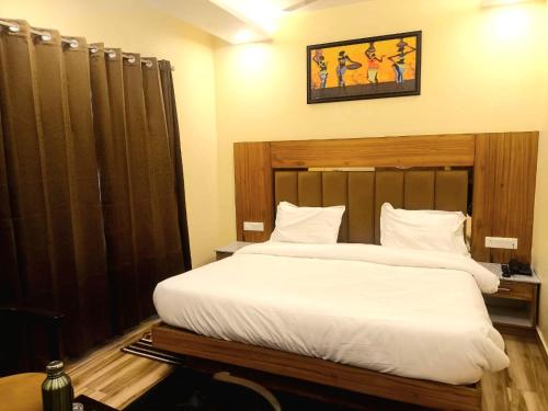 a bedroom with a large bed with white sheets at The Boho Mussoorie in Mussoorie