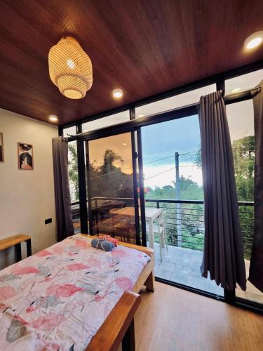 a bedroom with a bed and a large window at Romantic Chic Cottage with View in Tuba