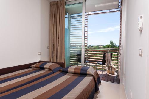 two beds in a room with a balcony at Residence Delfina in Rimini