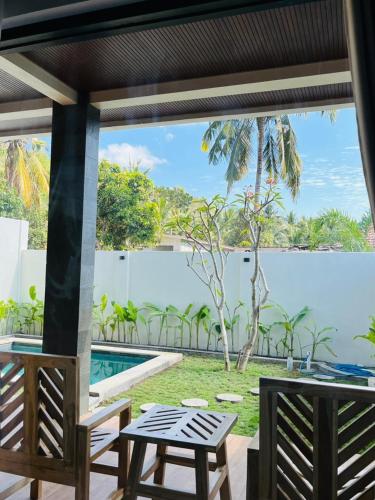 a patio with a table and chairs and a view of the water at The Res Village Lombok in Kuta Lombok