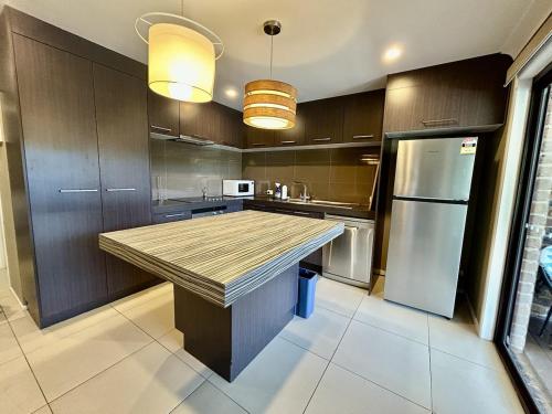 a kitchen with a large island in the middle at Enjoy your Private Pool between BNE and Gold coast in Tanah Merah