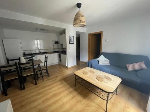 a living room with a blue couch and a table at La casita de Nicolás in Escarrilla