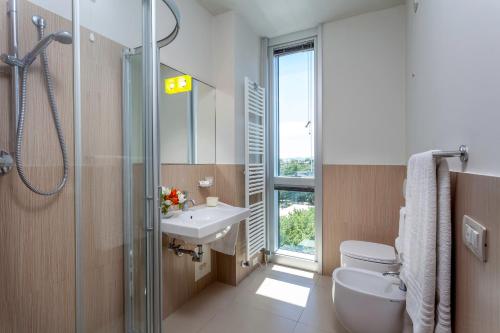 a bathroom with a sink and a toilet and a shower at Residence Delfina in Rimini