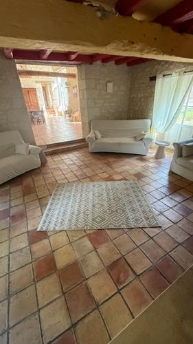 a living room with a couch and a tile floor at La Grange de la Boutelaye in Lésigny