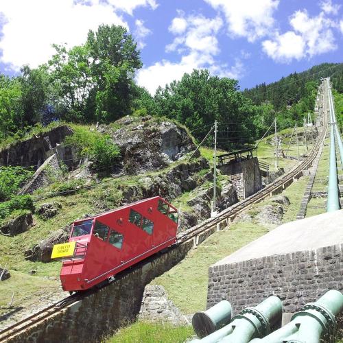 a red train is traveling down the tracks at Casa Da Tos - appartamento per 5 persone in Lavorgo