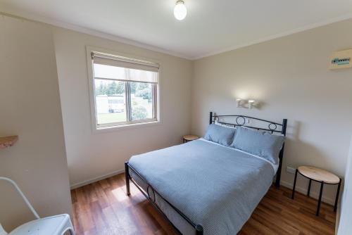 un dormitorio con una cama y una ventana en Beachport Caravan Park, en Beachport