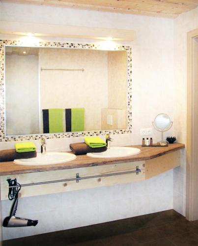 a bathroom with two sinks and a large mirror at Wiesennest in Fügenberg