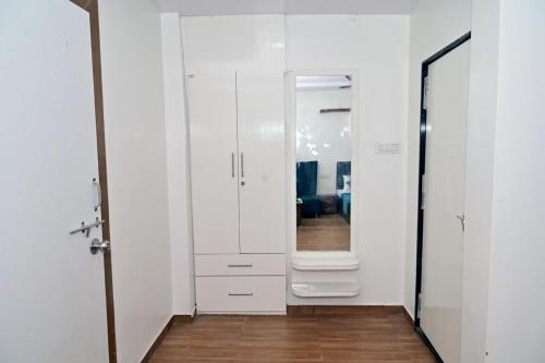 a hallway with a mirror and a white cabinet at Royal Tadoba Hotel in Chimur