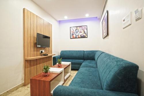 a living room with a blue couch and a tv at Hotel Ekta International !! 300 Mts From BABA BAIDYANATH DHAM TEMPLE !! in Deoghar