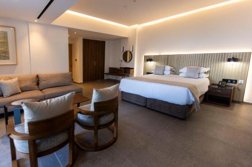 a large hotel room with a bed and a couch at Sofianna Resort & Spa in Paphos City