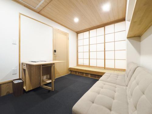 a room with a bed and a desk and window at Schanze Nozawa in Nozawa Onsen