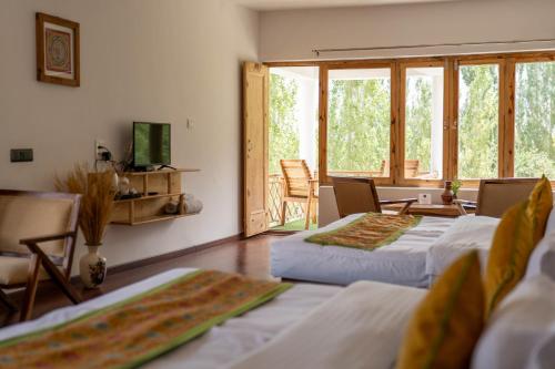 un soggiorno con 2 letti e un balcone di Hotel Karma Inn, Nubra Valley, Leh, Ladakh a Hundar