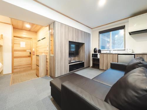 a living room with a couch and a television at Schanze Nozawa in Nozawa Onsen