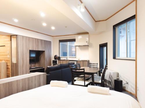 a room with a bed and a table and chairs at Schanze Nozawa in Nozawa Onsen