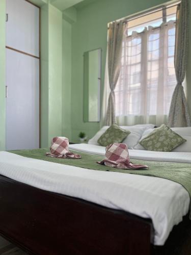 a bedroom with two beds with bow ties on them at Cozy Haven 1018 Homestay in Shillong