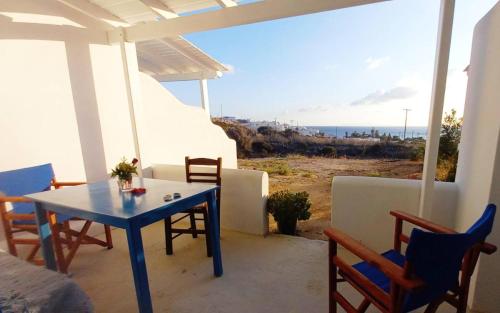 a blue table and chairs on a porch with a view of the ocean at Στούντιο 1 in Donoussa