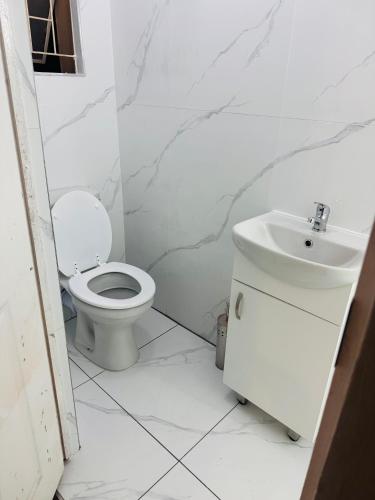 a white bathroom with a toilet and a sink at Nampaton Farm in Drummond