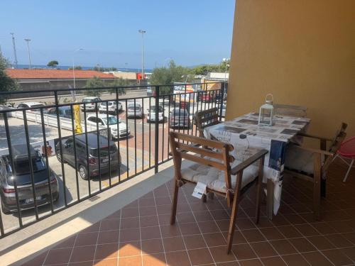 a balcony with a table and a view of a parking lot at Giorni fantastici - appartamenti fronte mare in Marina di Ascea