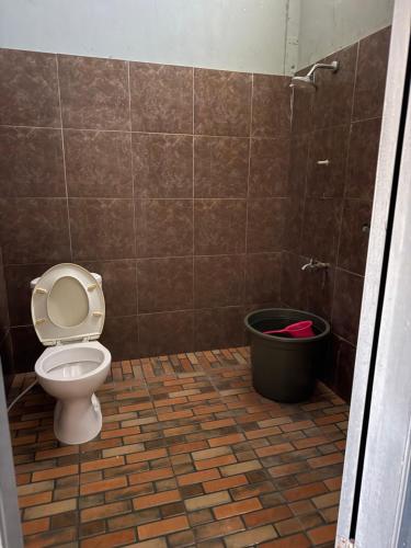 a bathroom with a toilet and a trash can at Sumbawa Maluk Homestay Kost tika in Maluk