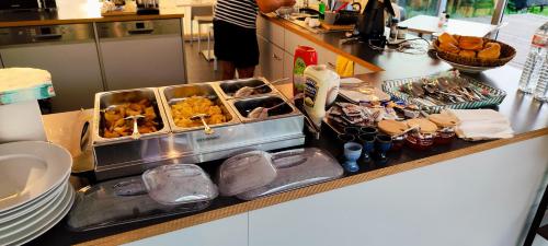 a kitchen with a counter with dishes and food at Sport Arena HOTEL Waldshut in Waldshut-Tiengen