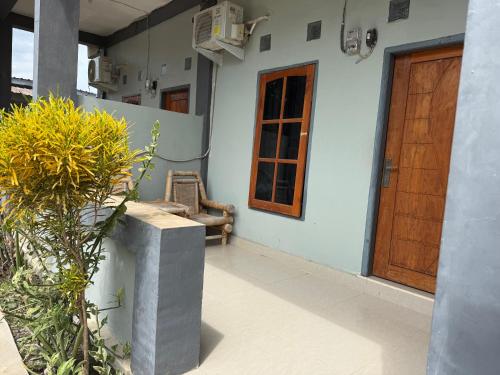 a porch of a house with a door and a chair at Sumbawa Maluk Homestay Kost tika in Maluk