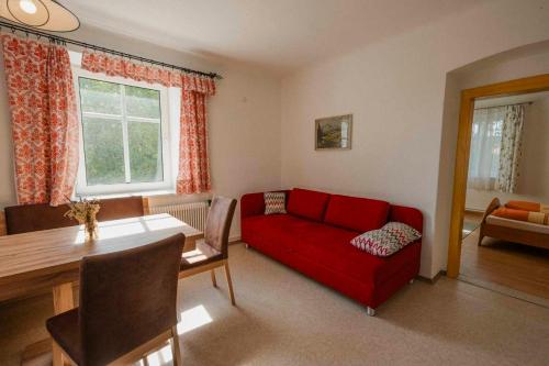 a living room with a red couch and a table at Gasthof Speneder in Altpölla